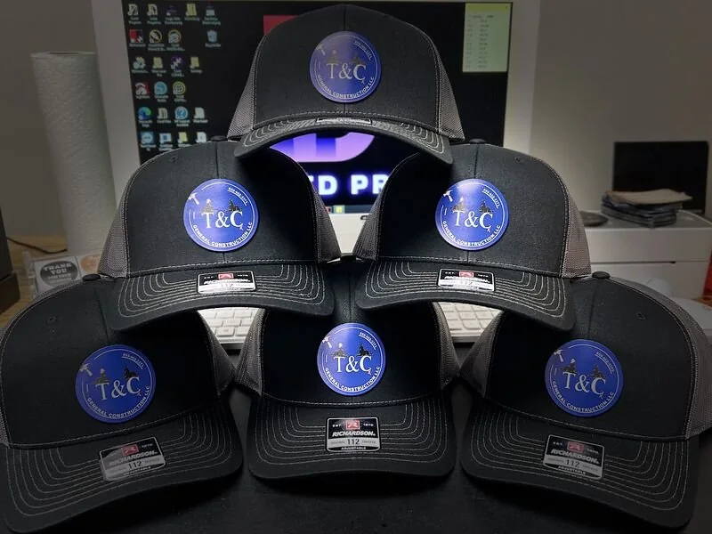 Six black caps with printed patches